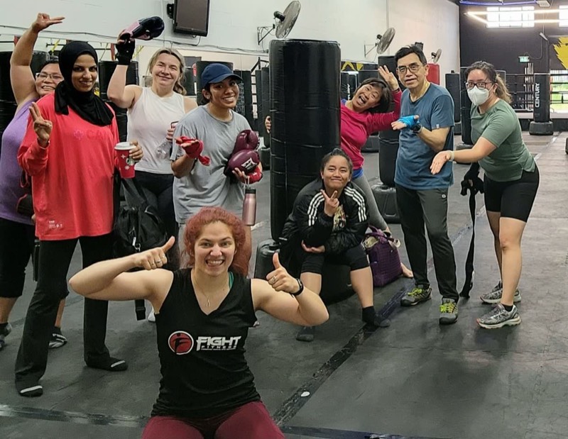 Group of members with heavy bags after kickboxing class